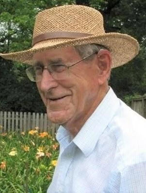 Photo of Stanley John Murdock wearing a straw hat, glasses, and a light blue shirt